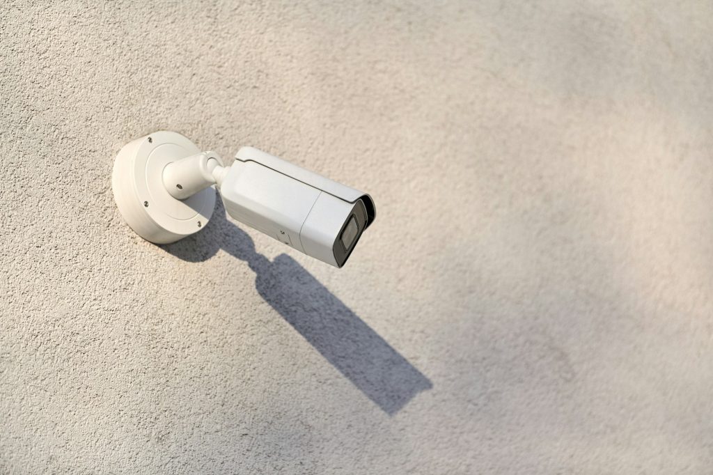 IP CCTV security camera on concrete wall, urban cityscape
